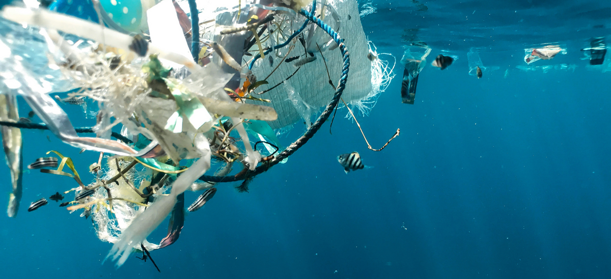 Plastic floating underwater in the ocean.